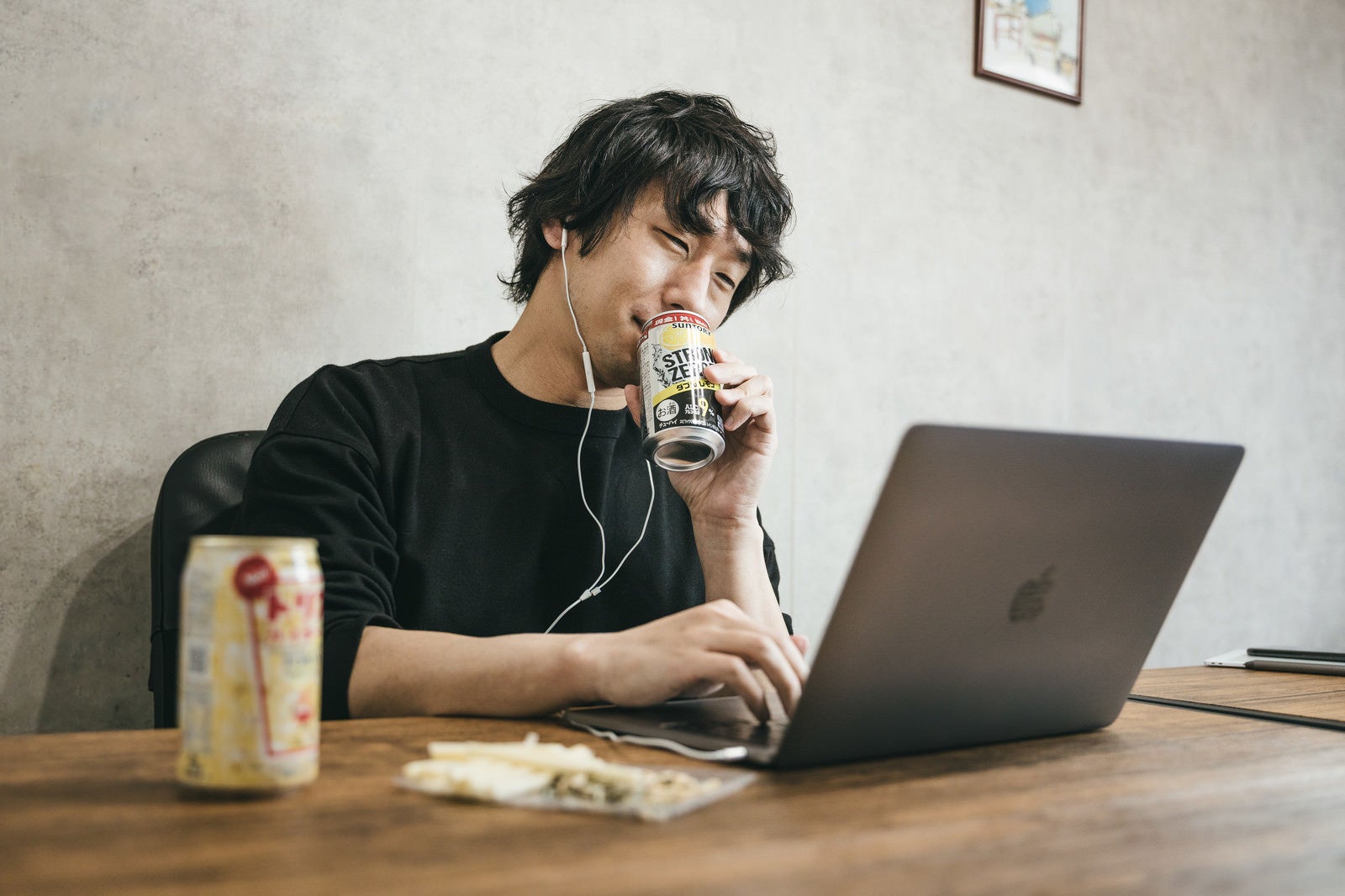 「缶チューハイを飲みながら在宅勤務しているエンジニア」の写真［モデル：大川竜弥］