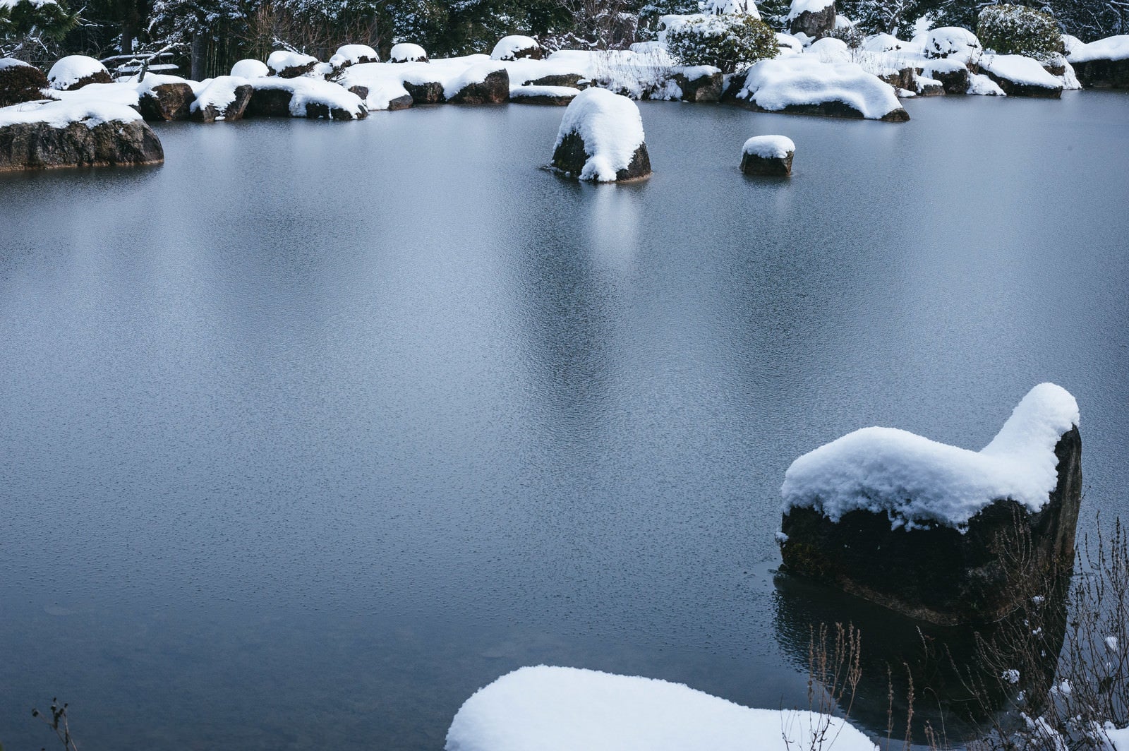 「雪が反射して白く映る水面」の写真