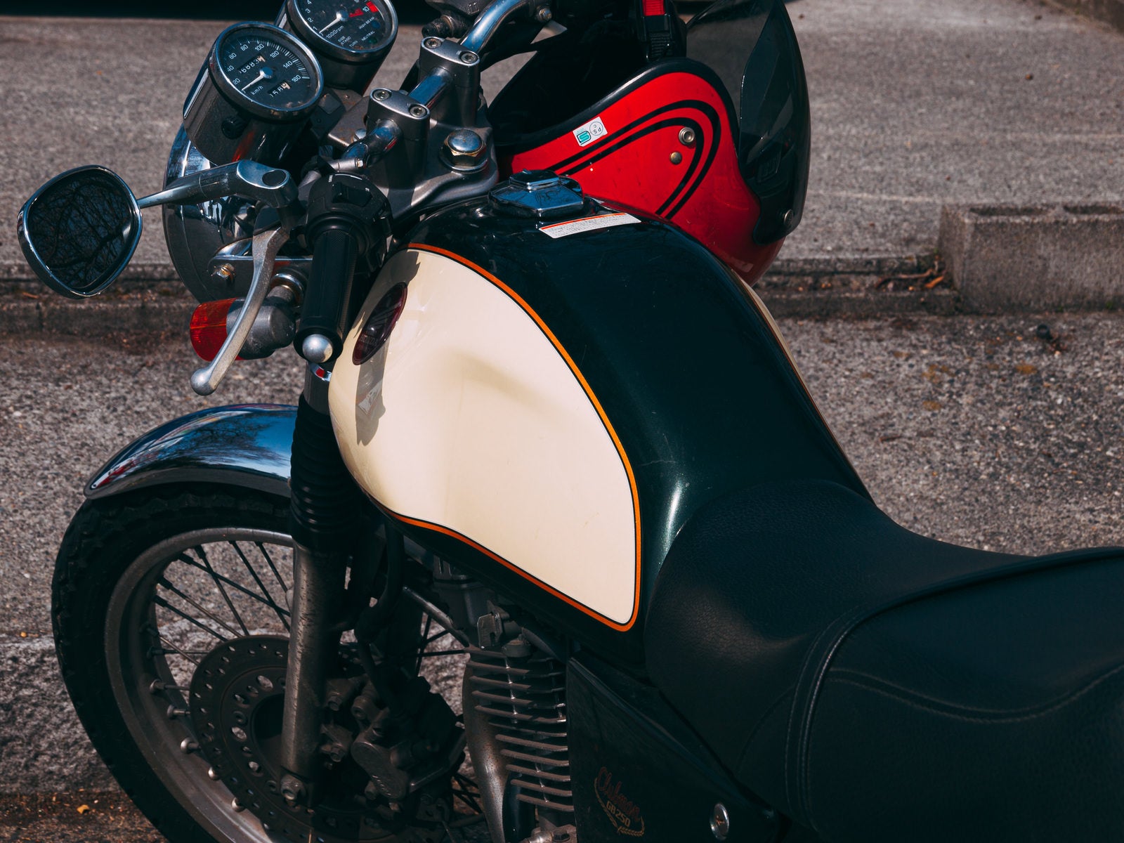 黒いSR400バイクの燃料タンクに赤いヘルメットが置かれている