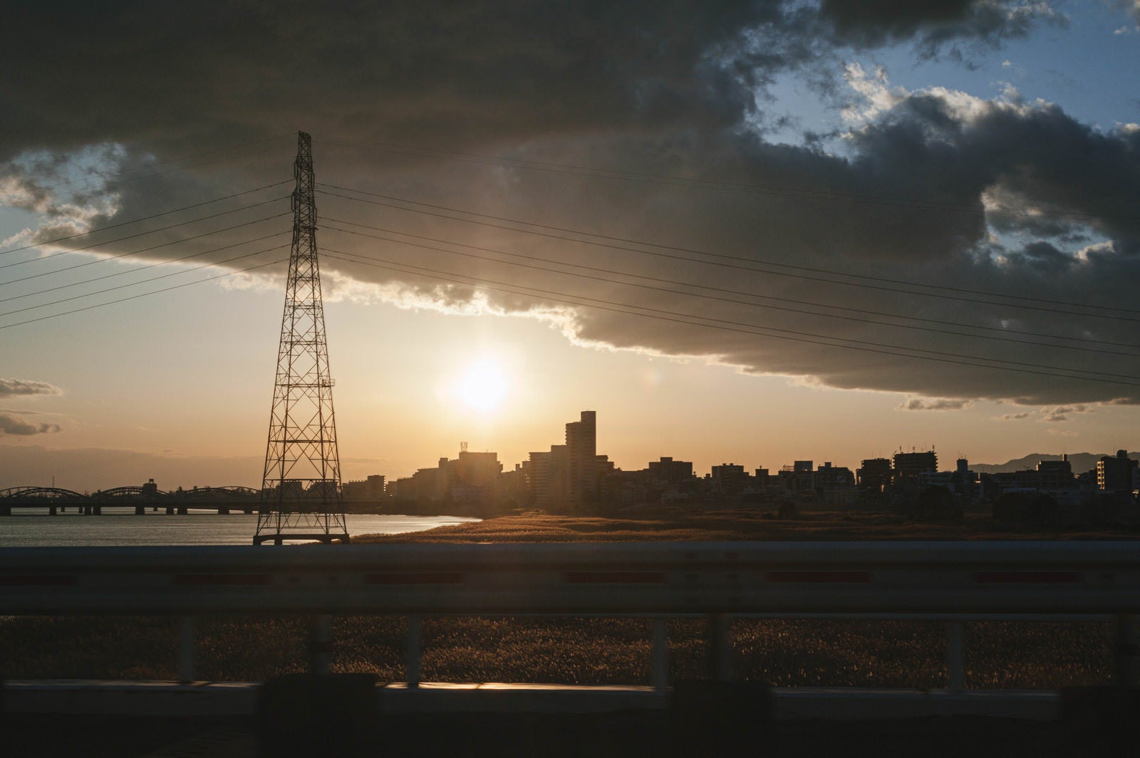 「帰り道の夕日と鉄塔」の写真