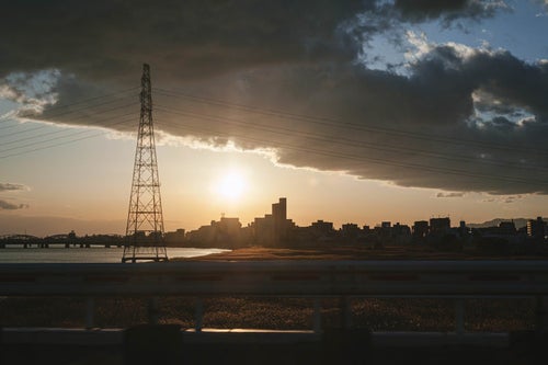 帰り道の夕日と鉄塔の写真
