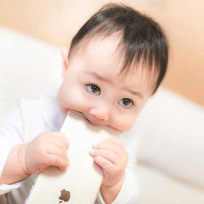 新しいスマートフォンを食べる赤ちゃんの写真