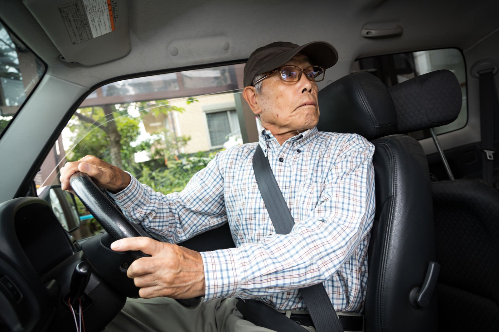 「駐車中にアクセルとブレーキを間違えて慌てる高齢者」の写真［モデル：まーちゃん］