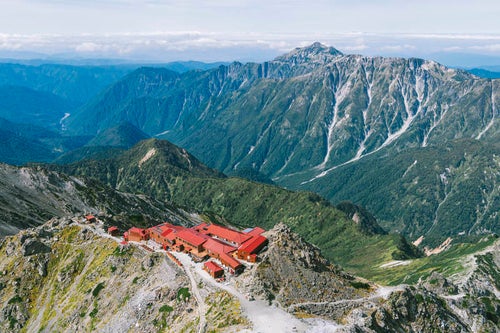 槍ヶ岳の山荘と笠ヶ岳の遠景の写真