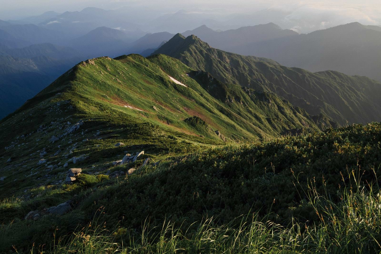 「夜明けの飯豊本山からダイクラ尾根を眺める」の写真
