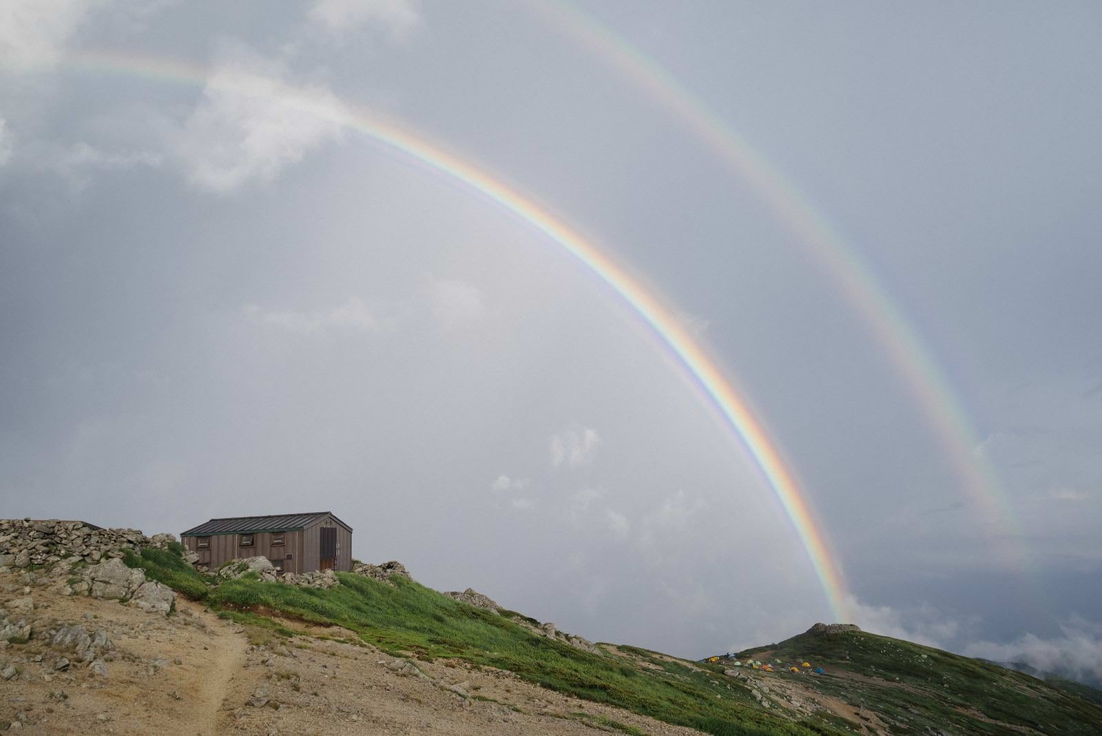 「本山小屋と重なった虹」の写真