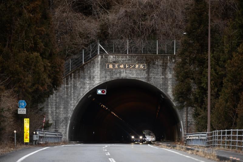 山道を走る車が通過する龍王峡トンネルの昼間風景
