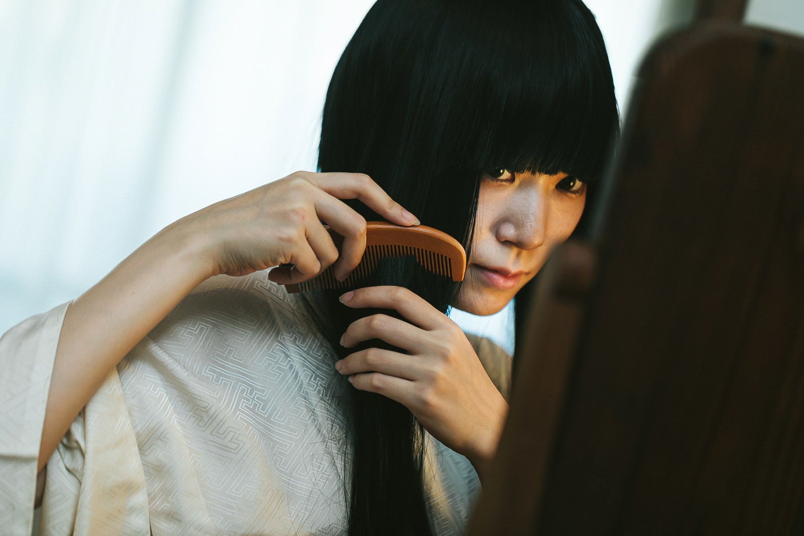 「長い黒髪をとかす女性」の写真［モデル：緋真煉］