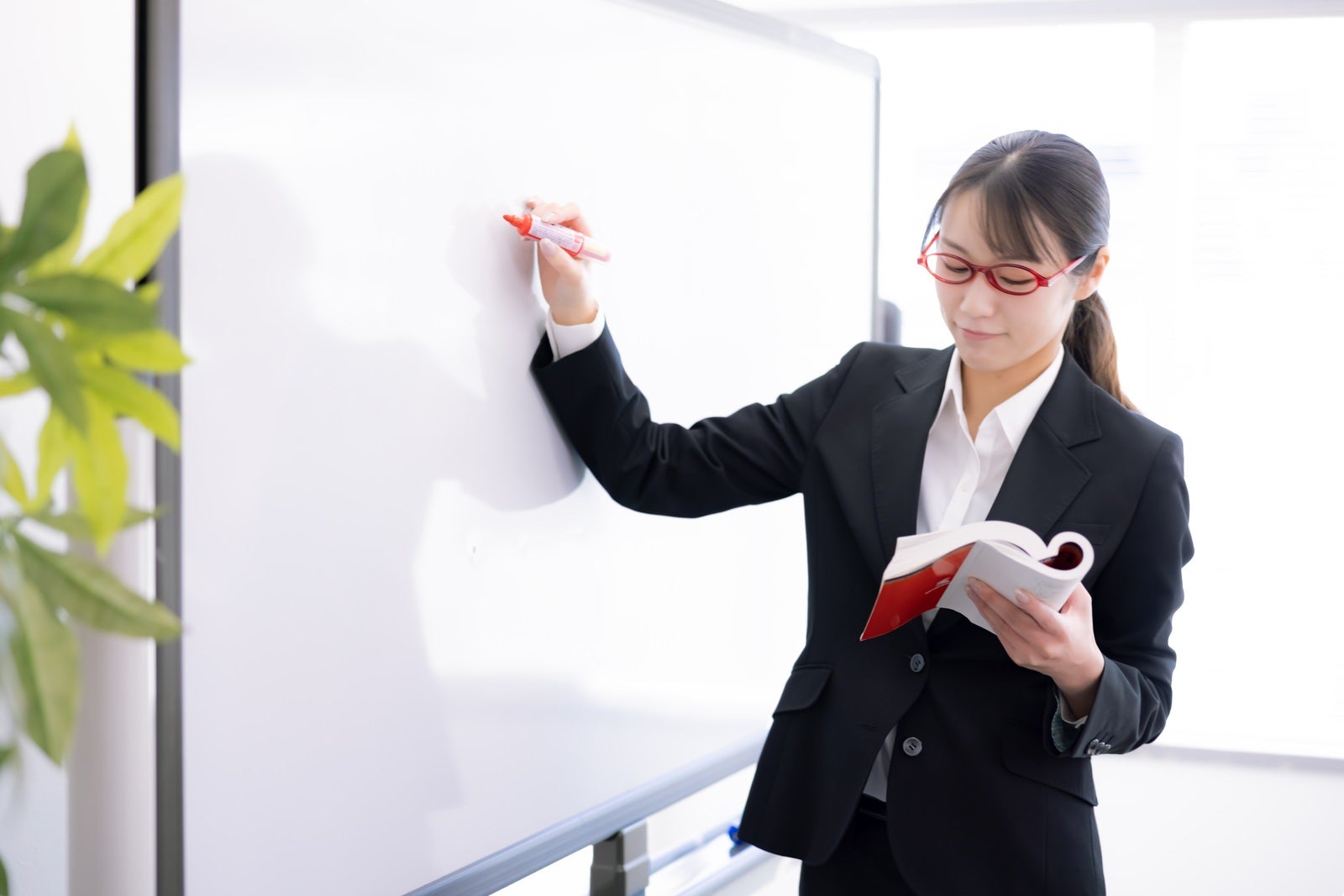 「ホワイトボードで授業をする女子講師」の写真［モデル：SAKI］