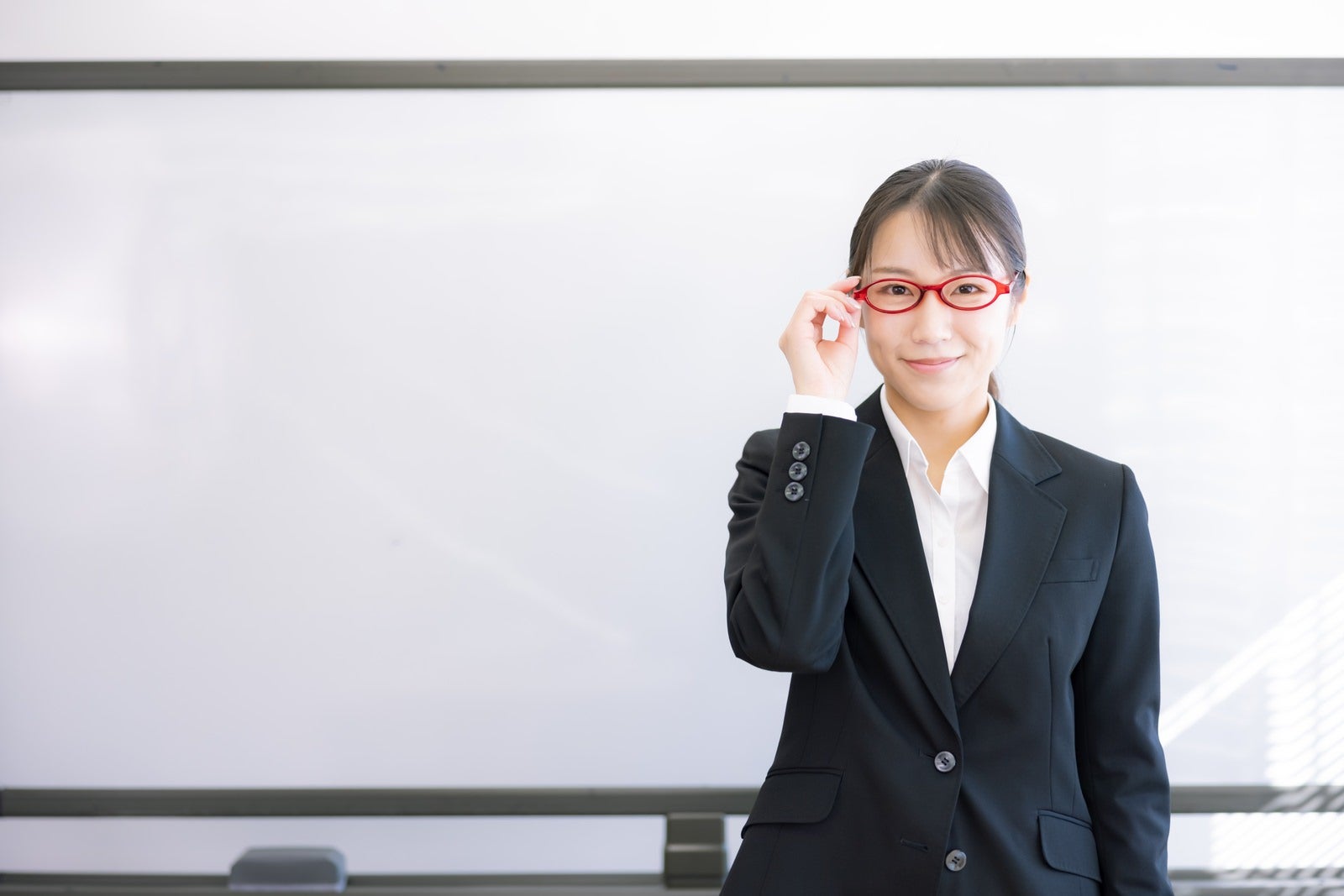 「赤い眼鏡がトレードマークの女性講師」の写真［モデル：SAKI］
