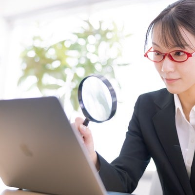 虫メガネを持つ女性社員の素材