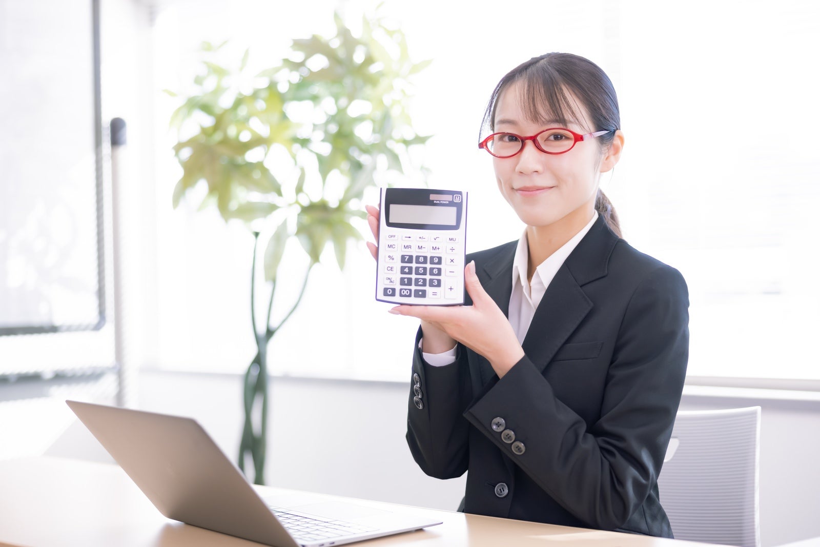 「おすすめの計算機を紹介する女性」の写真［モデル：SAKI］