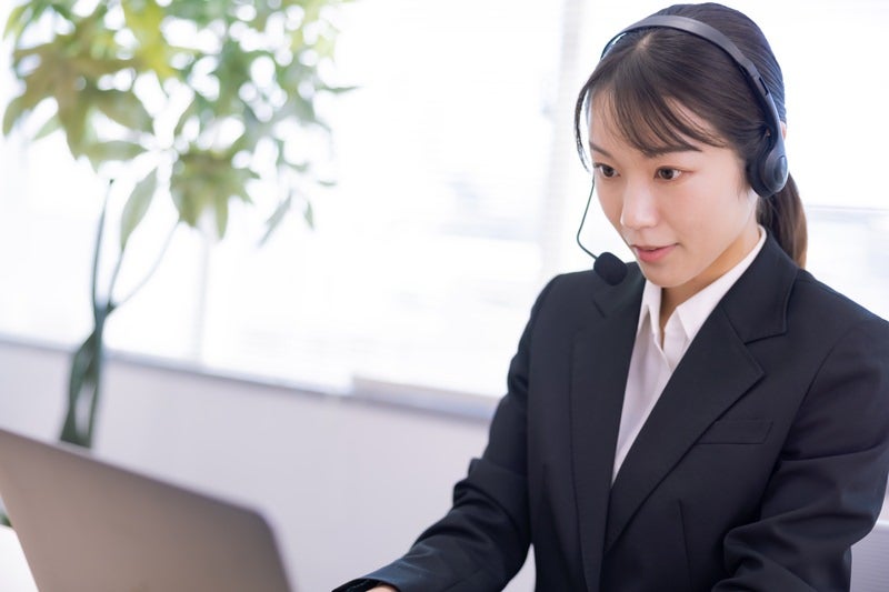ヘッドセットを付けてパソコンに向かうオペレーターの女性