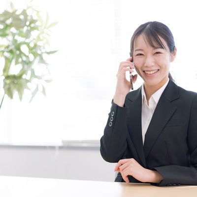 笑顔で通話する女性事務員の写真