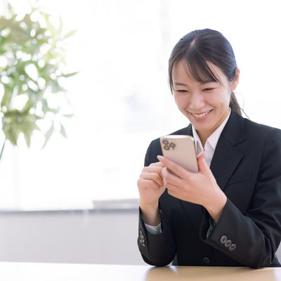 スマホが手放せない女性の写真