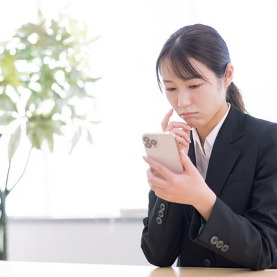 スマホ操作に戸惑う女性の写真