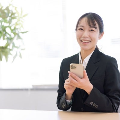 スマホ操作を教える女性社員の写真