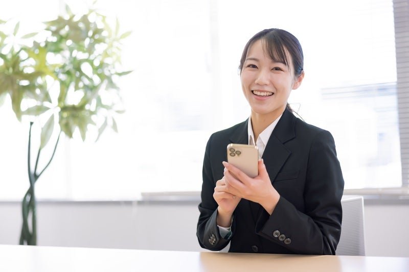 スマホ操作を教える女性社員の写真