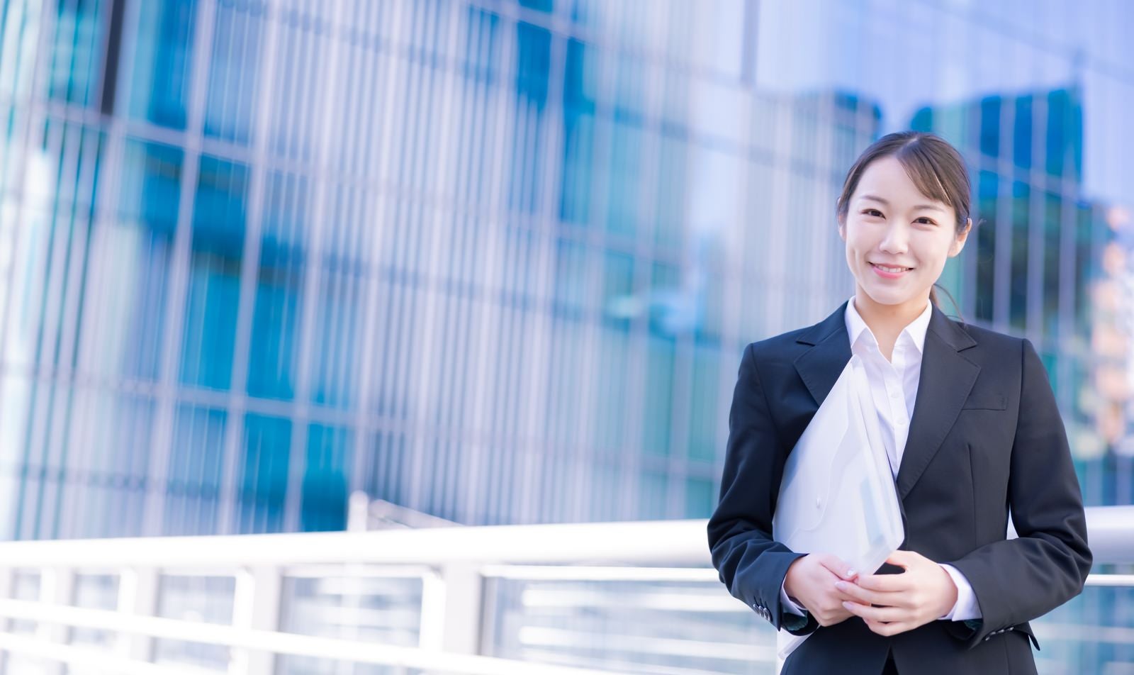 「ファイルを持って会議に向かう女性」の写真［モデル：SAKI］