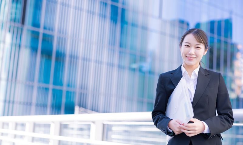 ファイルを持って会議に向かう女性の写真