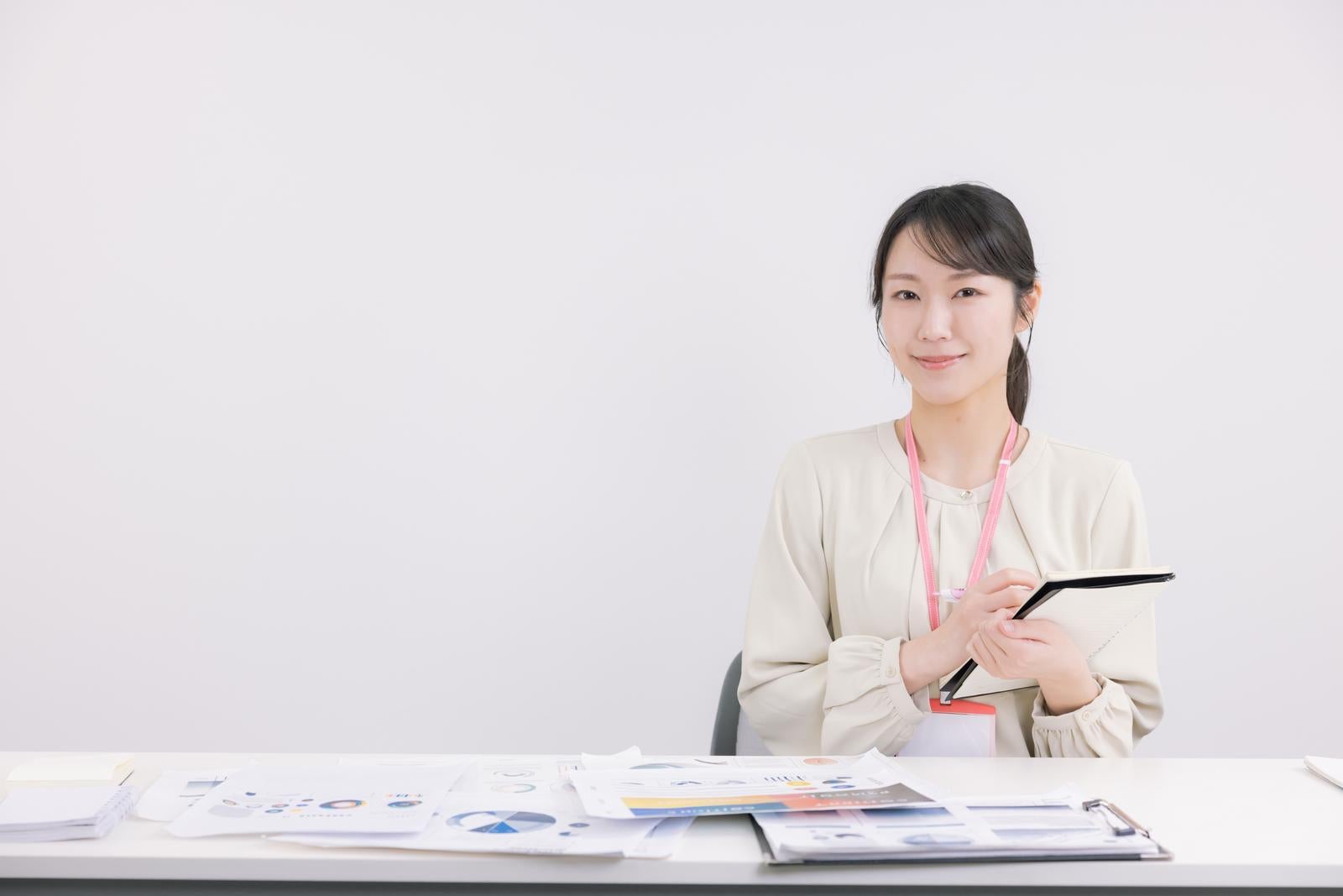 「書類と会議室でメモを取る女性」の写真［モデル：SAKI］