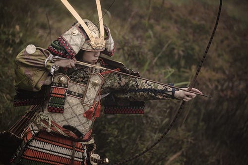 大弓で獲物を追う武士の写真