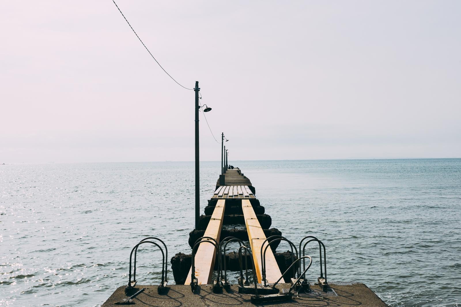 「桟橋の一部が壊れて立ち入り禁止になっている「原岡桟橋」で撮影を楽しむバカップル」の写真