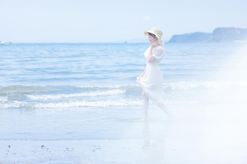 夏のビーチ、彼女と波打ち際の瞬間の写真