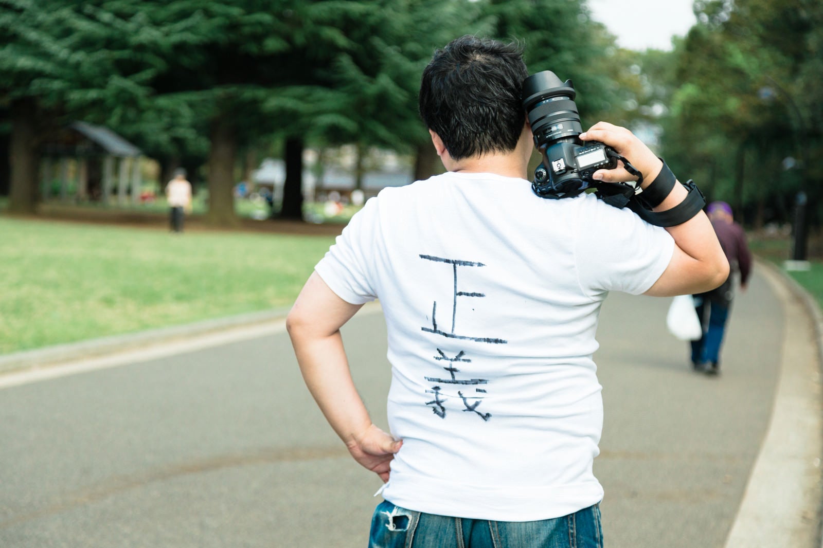 「ウンチクが多そうなカメラマンさんの後ろ姿」の写真［モデル：段田隼人］