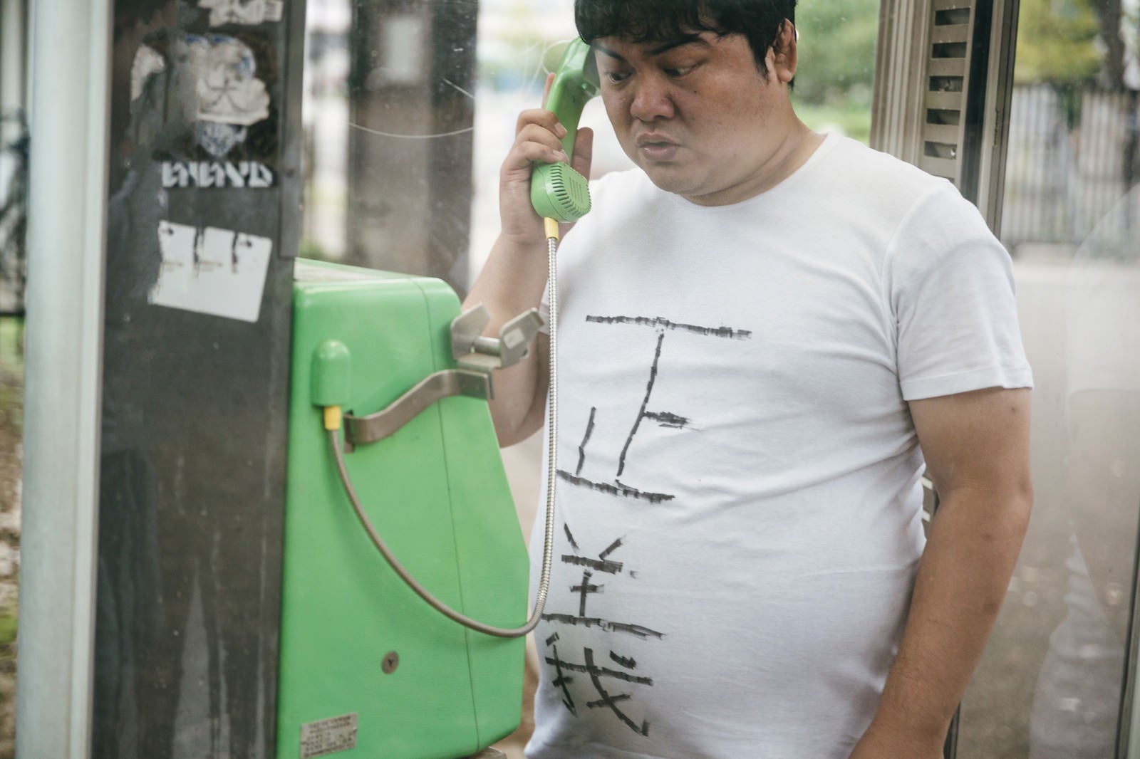 「公衆電話から匿名のタレコミをする男性」の写真［モデル：段田隼人］