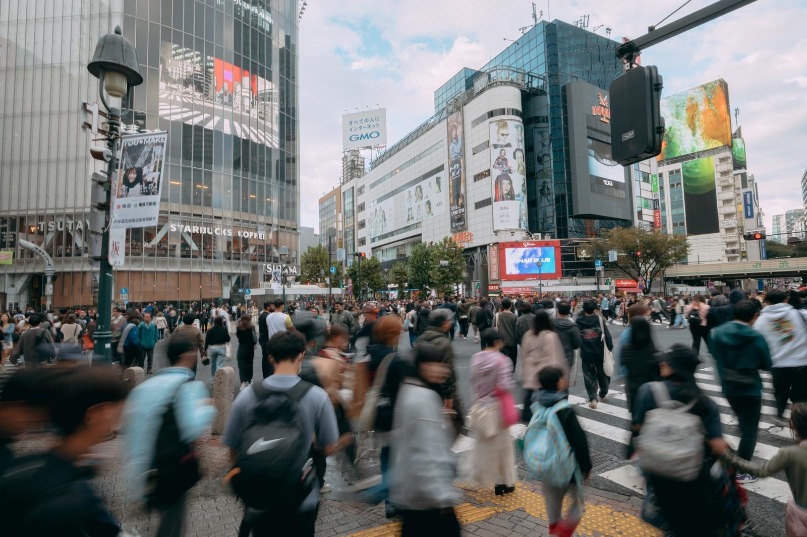 「渋谷スクランブル交差点を渡る歩行者の様子」の写真