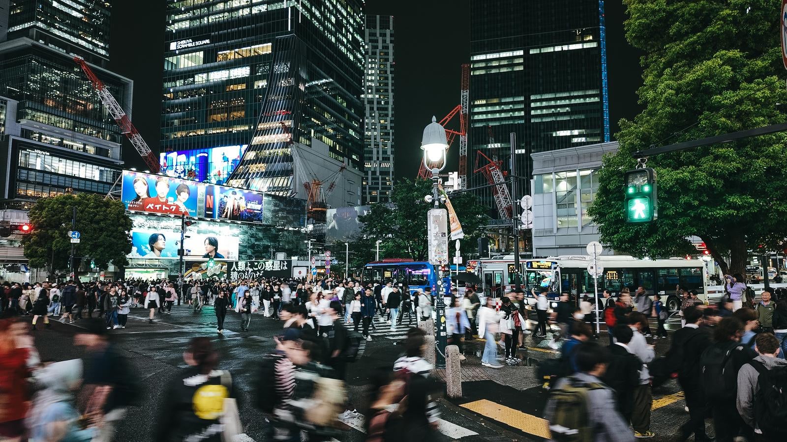 「青信号で一斉に歩き出す渋谷スクランブル交差点の人混み」の写真