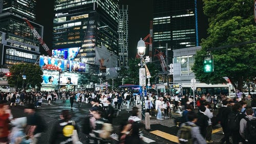 青信号で一斉に歩き出す渋谷スクランブル交差点の人混みの写真