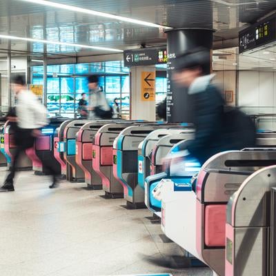 都会の朝を刻む地下鉄改札機と通勤客の躍動の写真