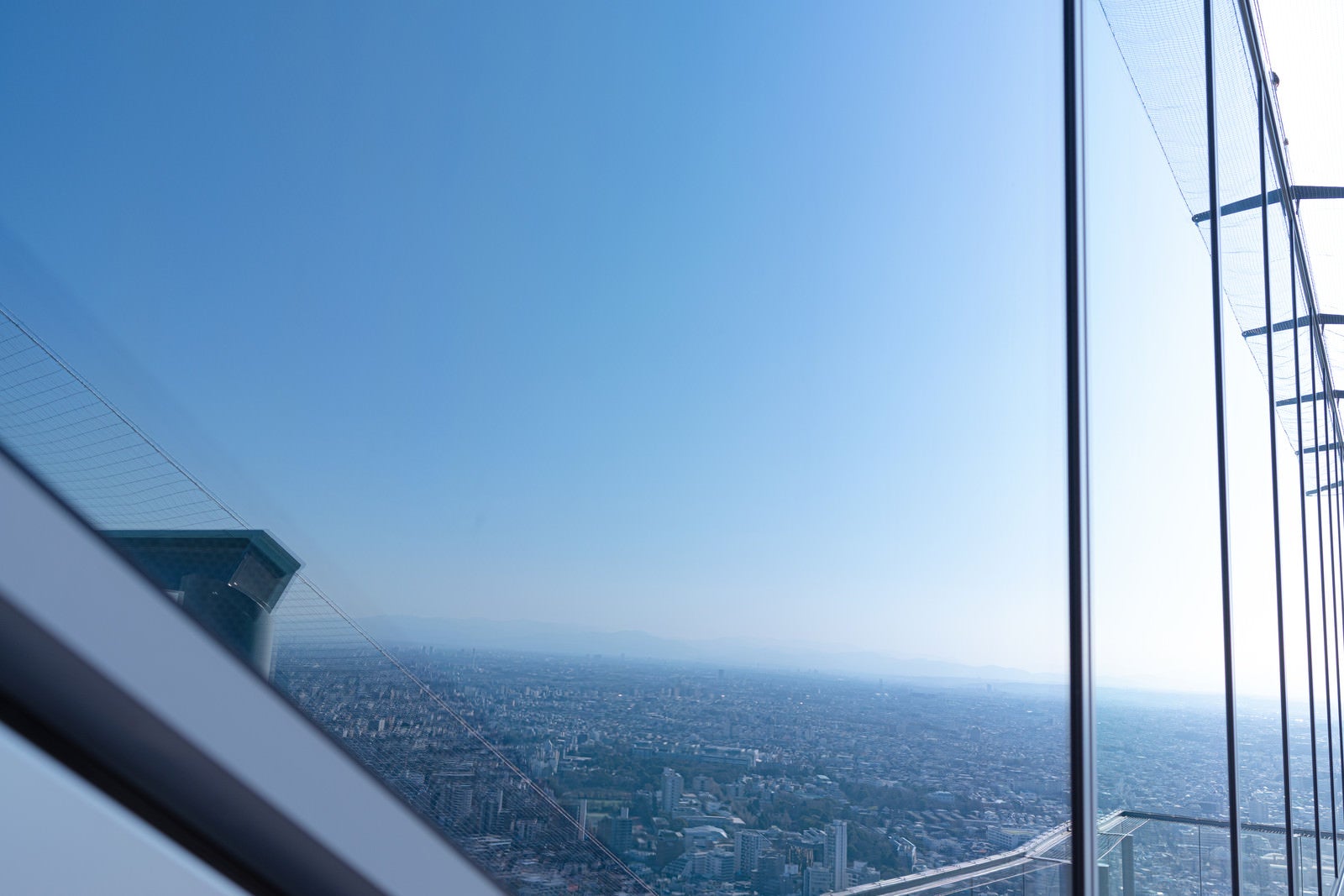 「鏡のような窓に写り込む都市景観（渋谷スカイ）」の写真