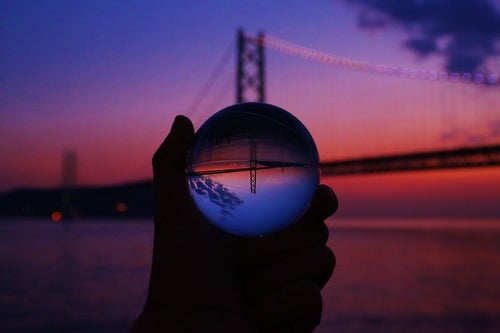 夕暮れ時のブリッジと反転して映る水晶球の写真