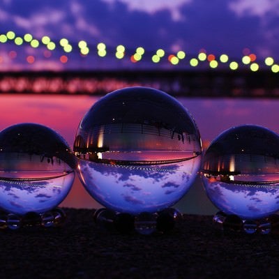 ライトアップした大橋と映り込む水晶球の写真