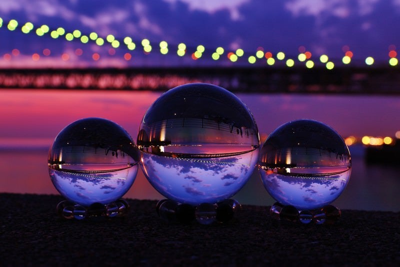 ライトアップした大橋と映り込む水晶球の写真