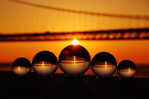 日の出が橋にかかる様子と水晶球の写真