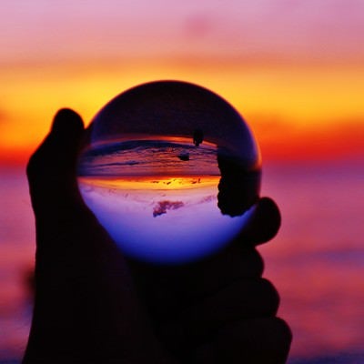 オレンジ色の夕焼けを水晶球から眺めるの写真