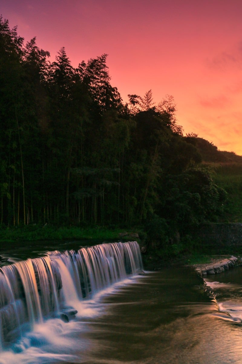 「赤く染まる夕刻の空と滝」の写真