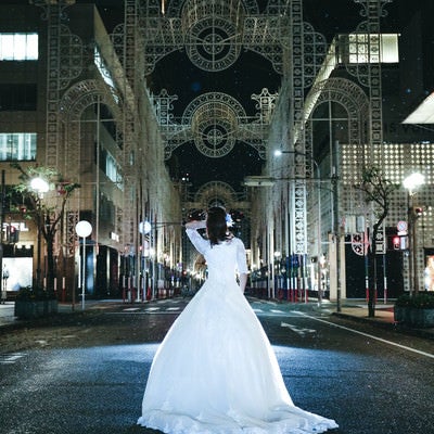 小雨が降る点灯前の神戸ルミナリエとドレスの女性の写真