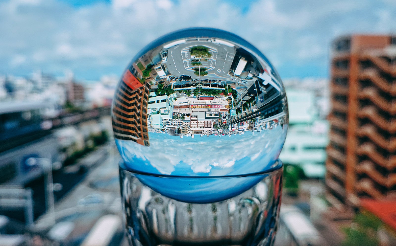 「グラスに置いたガラス玉から見る街なみ」の写真