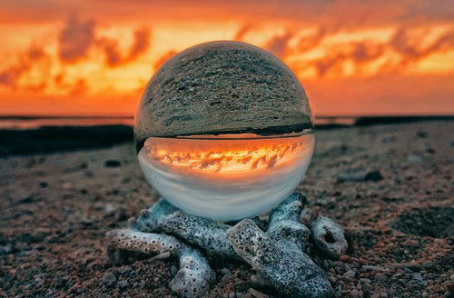 ガラス玉から見る燃えるような夕焼けの写真