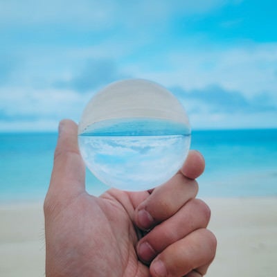 水晶玉から覗く南国の砂浜の写真