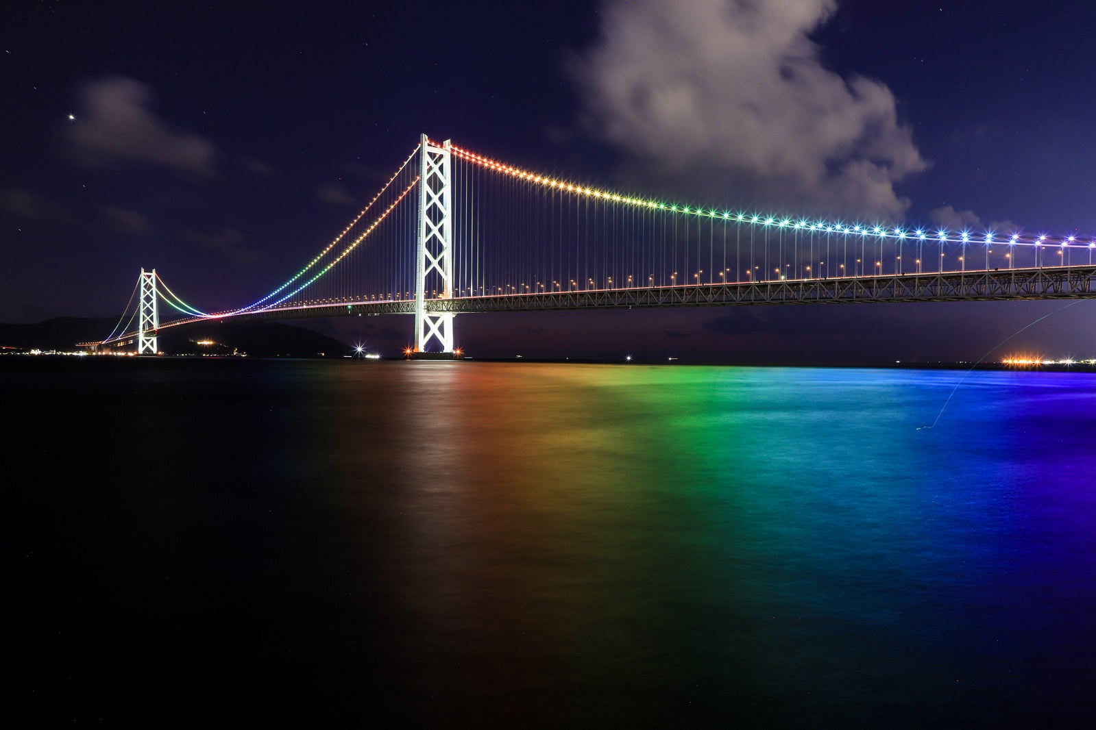 「レインボーカラーにライトアップした海と明石海峡大橋」の写真