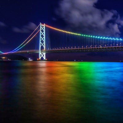 虹色にライトアップされた明石海峡大橋の写真