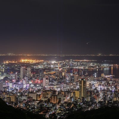 遠くに見る都市の夜景と港の写真