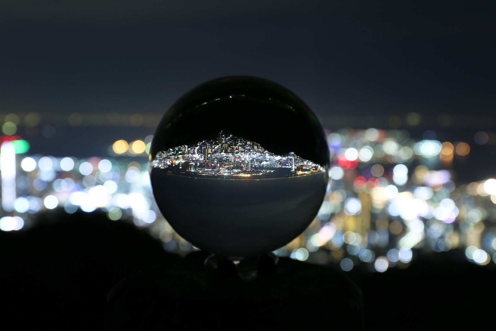 「ガラス玉に映る反転した夜景」の写真