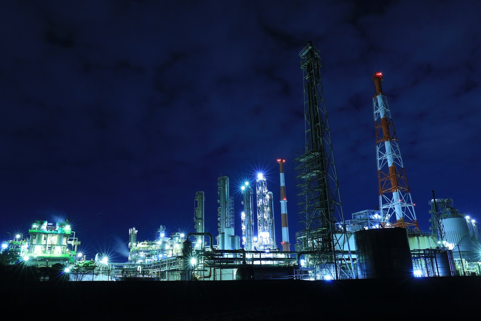 「工場夜景と立ち並ぶ鉄塔」の写真